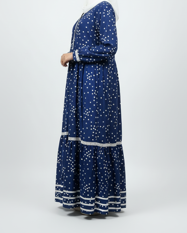 Woman wearing a blue dress with white patterns on a white background